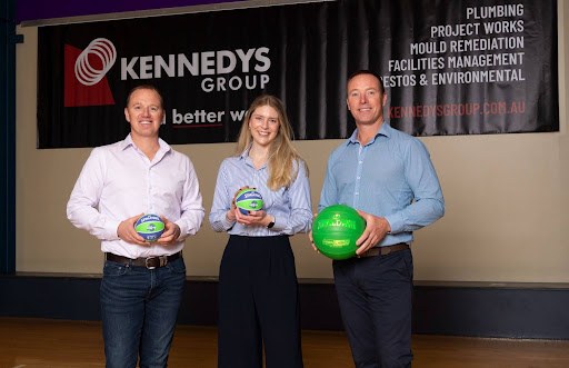 Kennedys Group representatives holding Geelong Venom-branded basketballs at a partner event
